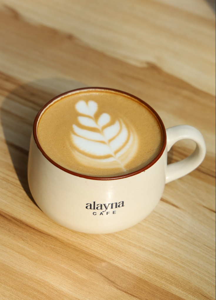 Alayna Cafe Shahpur Jat — branded latte cup