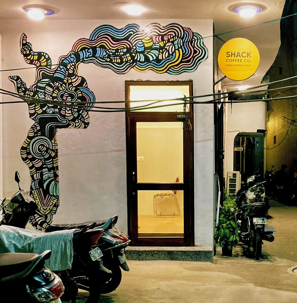 Shack Coffee interior Shahpur Jat — art wall, La Marzocco bar