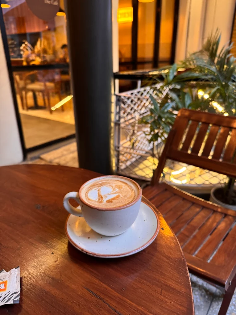 Specialty latte at Solchemi — warm cafe interior, Shahpur Jat