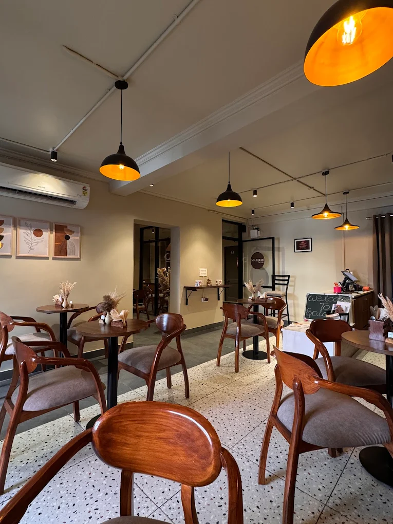 Solchemi cafe interior, Shahpur Jat — pendant lamps, wooden counter, work-friendly seating